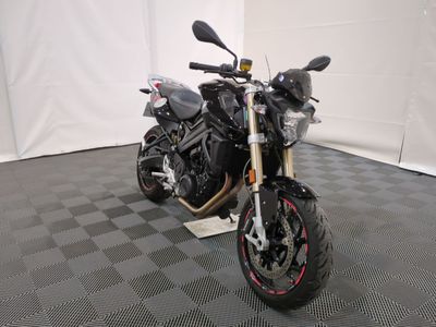 une moto qui est garée dans une pièce dont le sol est en damier