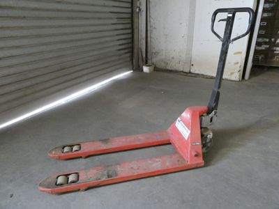 un chariot élévateur garé dans un garage dont la porte est ouverte