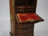 une armoire ancienne en bois avec un plateau en velours rouge