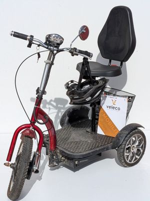un scooter rouge avec une selle noire et un coffre à l'arrière