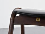 an image of a wooden chair with a black leather seat