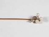an image of a close up of a hair pin with pearls on it