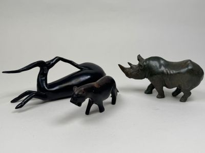 deux figurines représentant des rhinocéros et un éléphant sur un fond blanc
