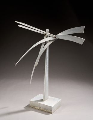 une photo d'une sculpture en métal posée sur un socle blanc