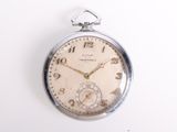 une montre de poche en argent posée sur une surface blanche