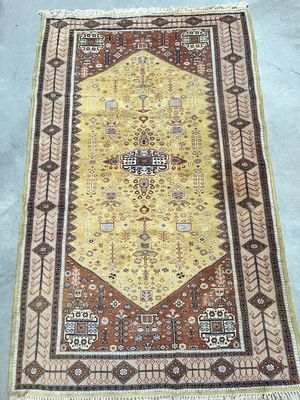 a yellow and brown rug sitting on top of a cement floor