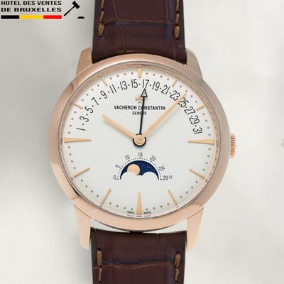a watch with a white dial on a brown leather strap