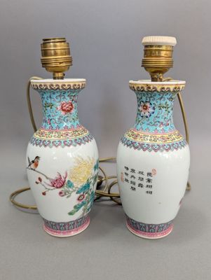 une paire de vases chinois décorés d'oiseaux et de fleurs, posés sur une table