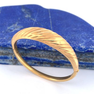 a close up of a gold ring on top of a blue stone