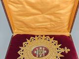 a gold medal in a red case on a table