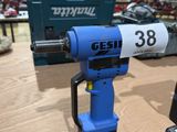 a blue and white drill on a table in a workshop