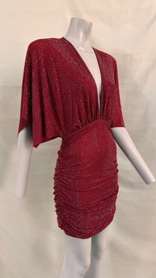 a mannequin dressed in a red dress with a cape over it