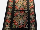 a close up of a black rug with red flowers on it