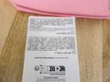 a pink bag sitting on a table next to a cell phone