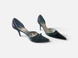 une paire de chaussures noires à talons hauts sur une surface blanche