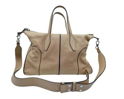 the large beige handbag is sitting on a white surface