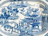 a blue and white plate with a picture of a town on it