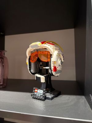 a lego star wars helmet on a shelf next to a mason jar