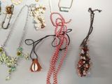 a lot of necklaces that are hanging on a wall