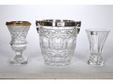 three glass vases and a silver vase sitting on a table