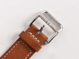a close up of a brown leather watch strap with a silver buckle