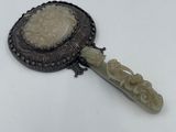 a close up of a small mirror with a handle on a white surface