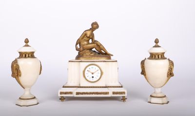 trois vases et une horloge posés sur une table