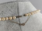necklace with pearls and a gold chain on a mannequin mannequin