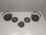 four teapots on a white table next to each other