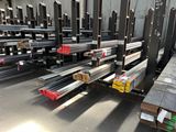 a large amount of steel bars are stacked on pallets in a warehouse