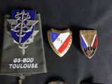 several military badges are laying on top of a black cloth