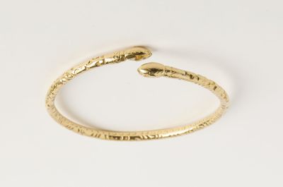 un gros plan sur un bracelet en or orné d'un serpent