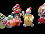 cinq figurines de clown alignées sur un fond noir