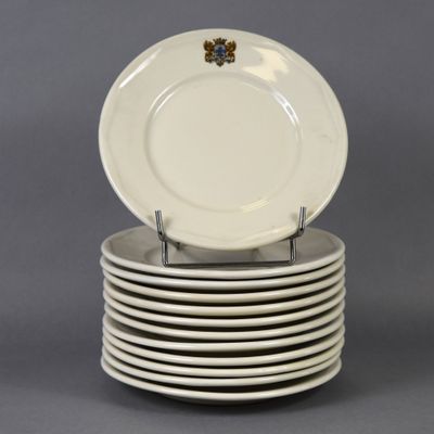 plusieurs assiettes blanches empilées les unes sur les autres sur une surface grise