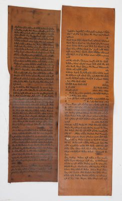 two pieces of brown paper with writing on them sitting on a table