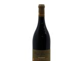 a bottle of wine sitting on top of a white surface
