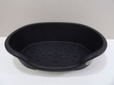 a black bowl with holes in it on a white surface