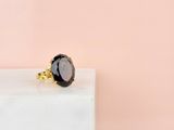 a black stone ring sitting on top of a white marble block