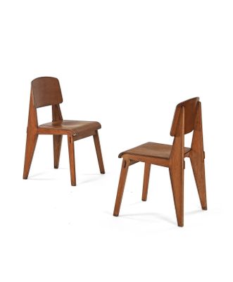pair of wooden chairs with leather seats on a white background
