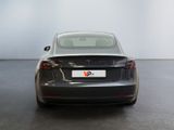 the back end of a black tesla model s in a white room