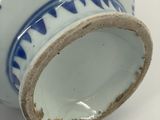 a blue and white vase sitting on a white surface