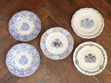 six blue and white plates on a wooden table with a wooden floor