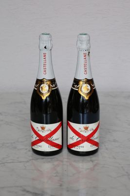 two bottles of champagne sitting on top of a marble counter top