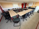 de nombreuses chaises disposées autour d'une table dans une salle de réunion
