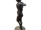 statue of a woman holding a baseball bat on top of a wooden base