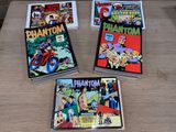 three comic books sitting on top of a table next to each other