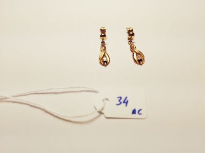two pairs of gold earrings and a price tag on a white surface