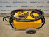a yellow cart with a hose attached to it sitting in front of a wall