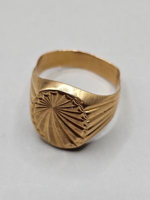 a close up of a gold ring on a white surface