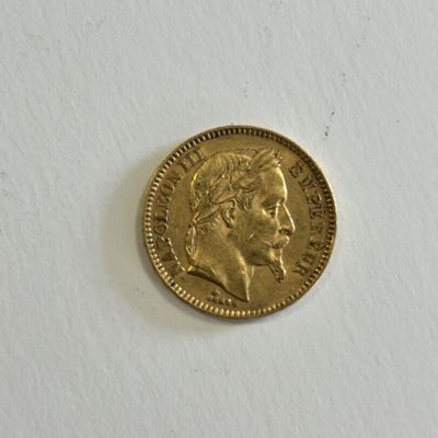 a close up of a gold coin on a white surface